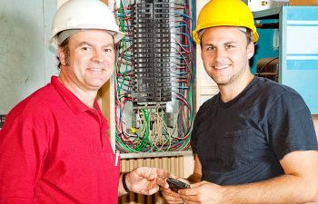 electrician and apprentice working on