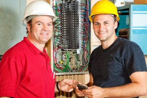 professional electrician and apprentice working on