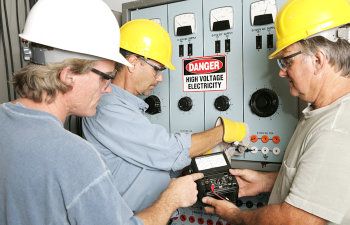 group of electricians using an ohm meter to test voltage